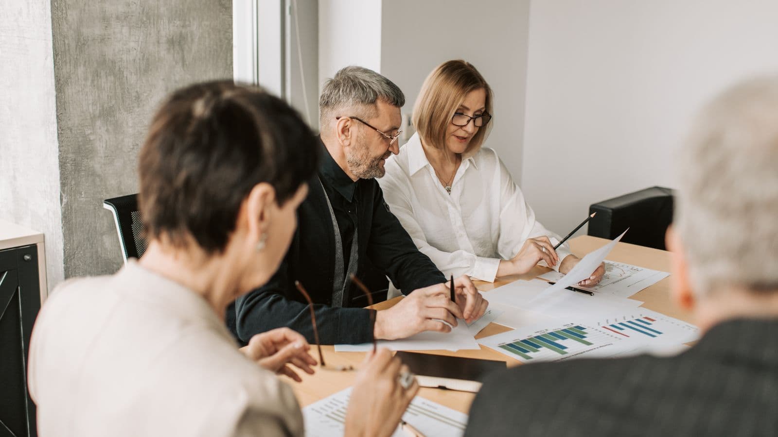 A team of finance professionals in an office analyzing financial documents and reconciliation strategy