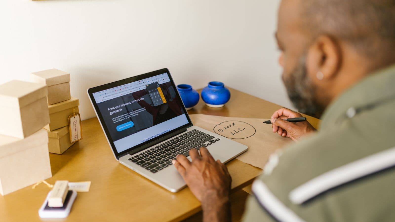 An entrepreneur at a desk using a laptop for accounting and bank reconciliation planning